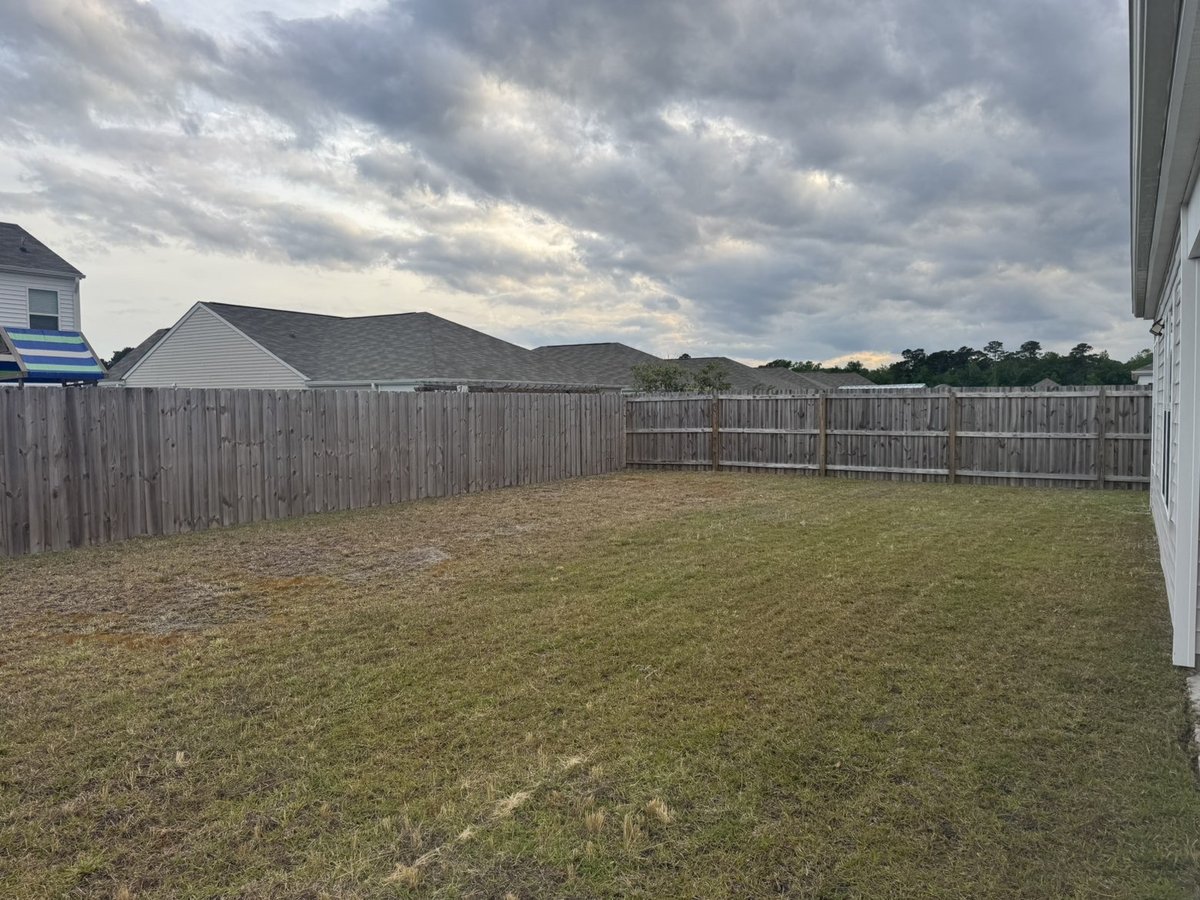 Mowed backyard with privacy fence, Live Oak Lawn Care job in Wilmington NC