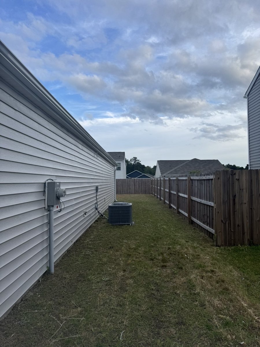 Mowed side passage between house and fence, professional lawn service Wilmington NC